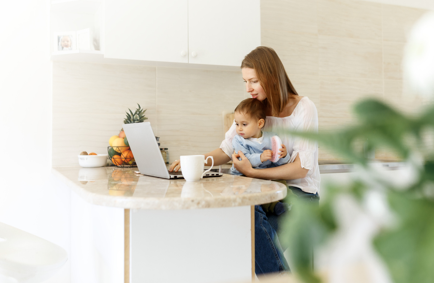 Young Woman with Baby Using a Laptop 